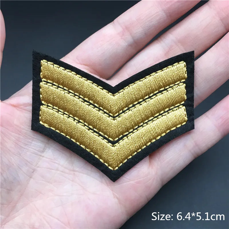 Gold military rank patch on a hand with size label