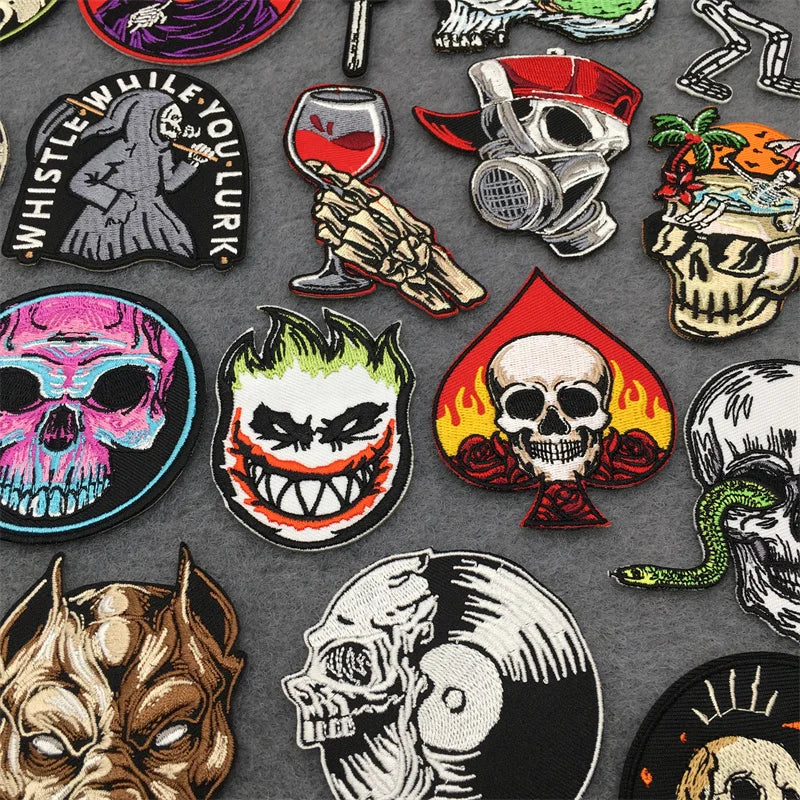 Collection of various skull-themed pins on a gray background