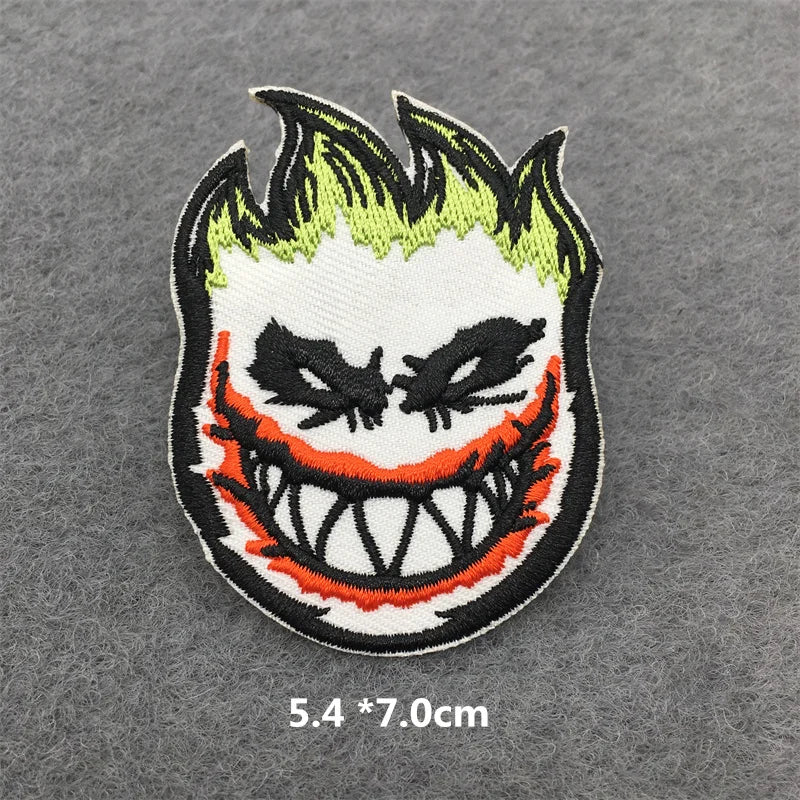 Embroidered patch of a character with green hair and red accents on a gray background