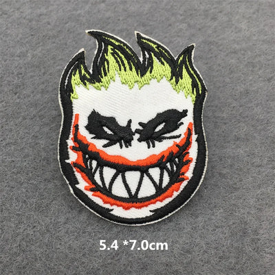 Embroidered patch of a character with green hair and red accents on a gray background