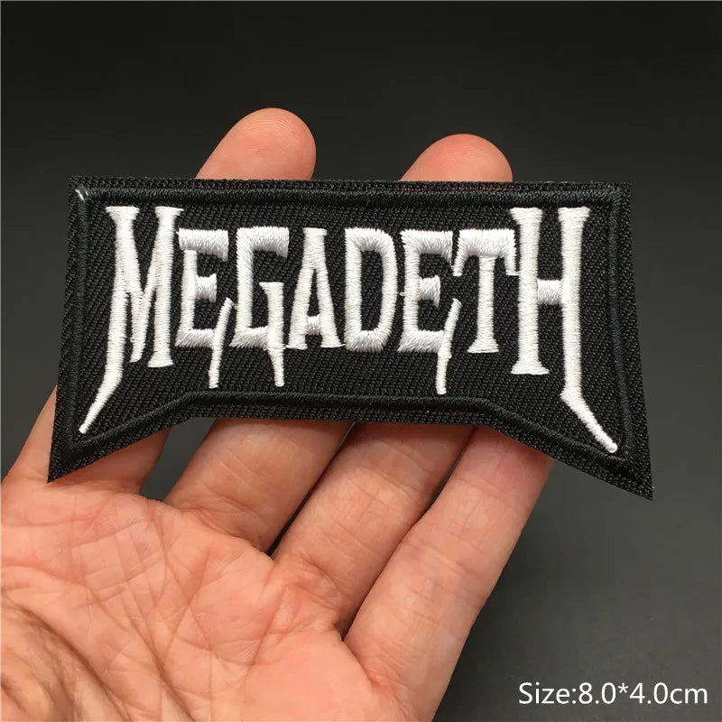 Megadeth logo patch held in a hand with a dark background