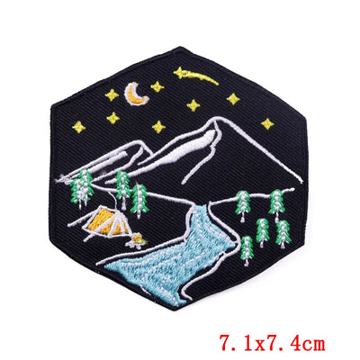 Embroidered patch with mountain and camping scene on a black background