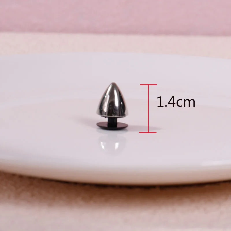 Metallic spike on a white surface with measurement label