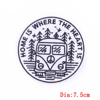 Circular design with a camper van, trees, and 'Home is where the heart is' text on a white background.