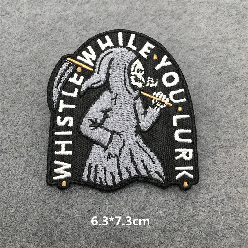 Embroidered patch with skeleton holding a whistle on a gray background