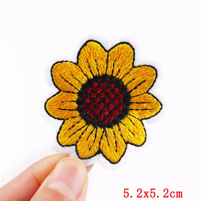 Sunflower-shaped patch held by a hand with dimensions indicated.
