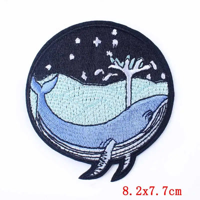 Embroidered patch of a whale with a starry night design on a black background