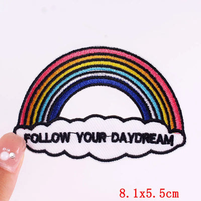 Embroidered patch with rainbow and cloud design on a white background
