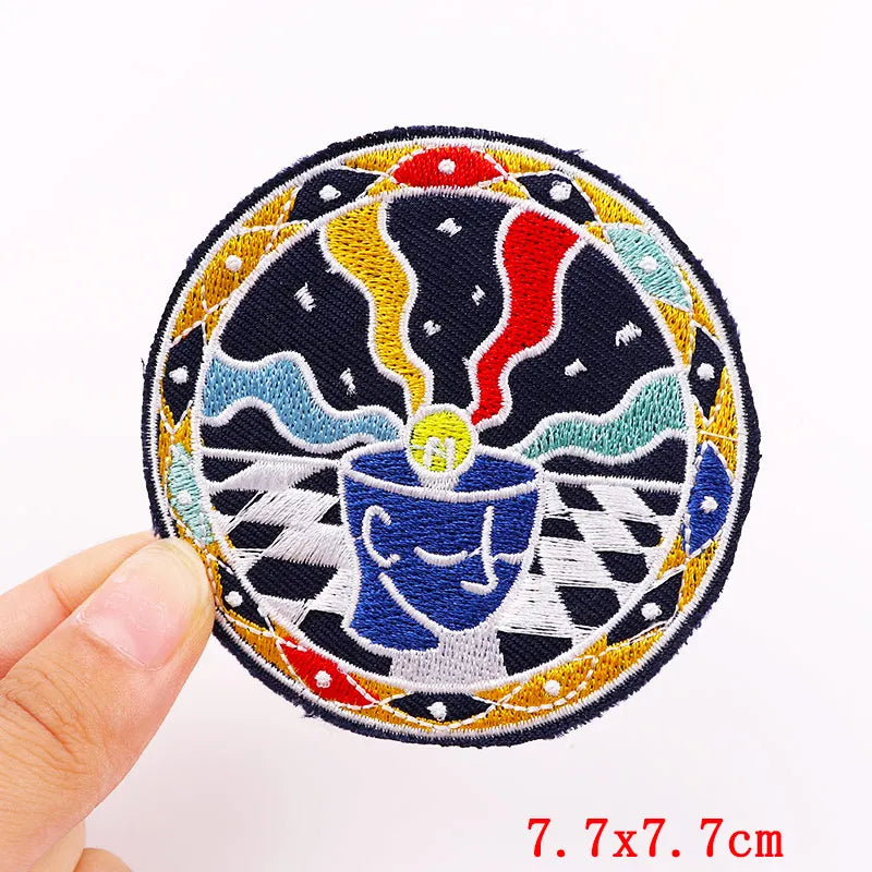 Colorful embroidered patch held by a hand with dimensions displayed.