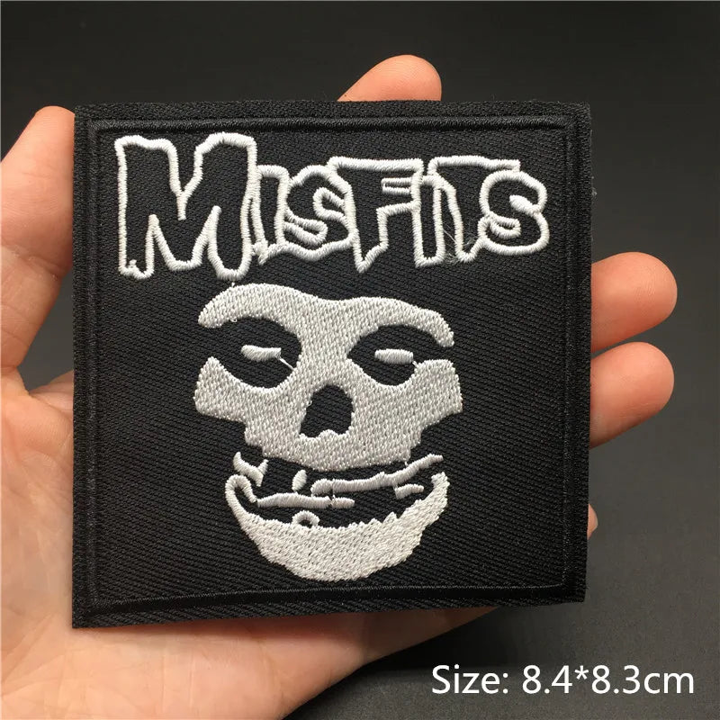 Embroidered patch with 'Misfits' logo held in a hand against a dark background