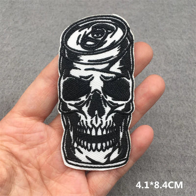 Skull and rose patch held in a hand with a gray background