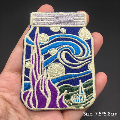 Embroidered patch of a bottle with wave design held in a hand, on a dark background.