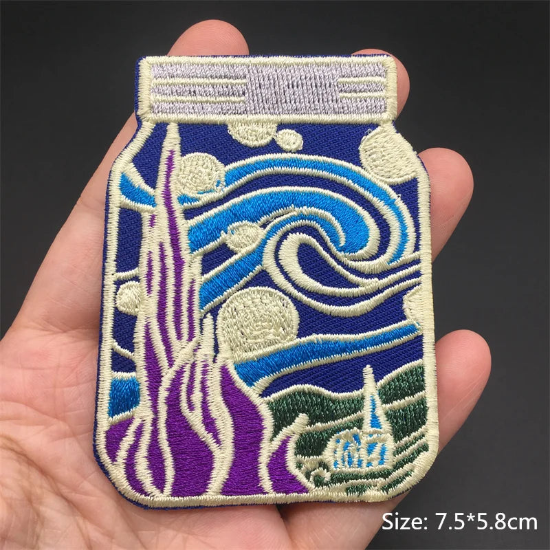 Embroidered patch of a bottle with wave design held in a hand, on a dark background