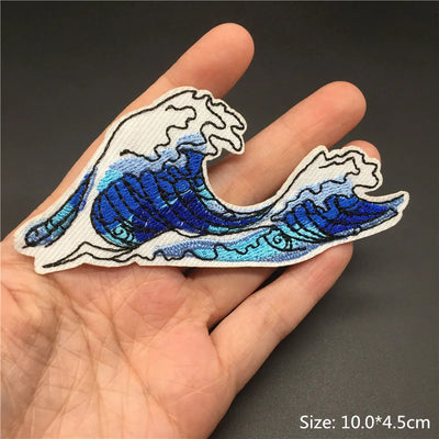 Wave-shaped patch held in a hand with a dark background