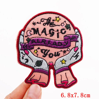 Embroidered patch with text 'The Magic is in You' held by a hand on a white background