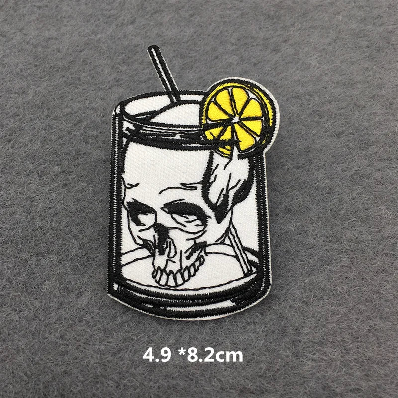 Skull-themed cocktail patch with lemon slice and straw on a gray background