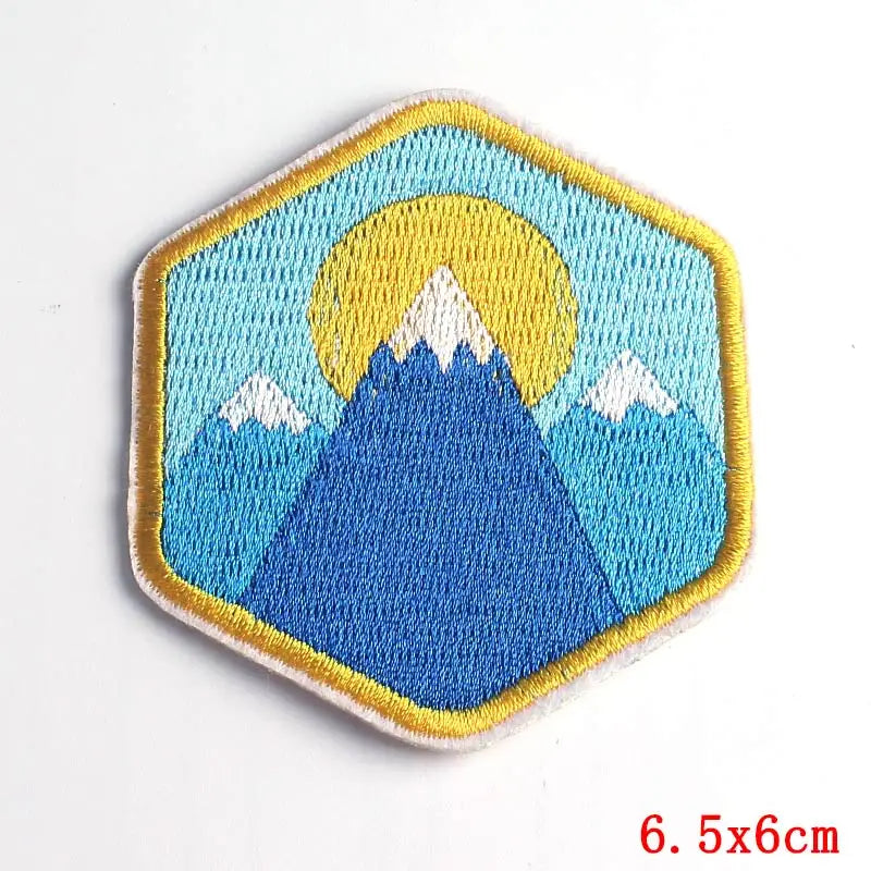 Hexagonal patch with mountain and sun design on a white background