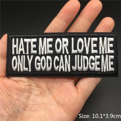 Embroidered patch with text 'HATE ME OR LOVE ME ONLY GOD CAN JUDGE ME' held in a hand.