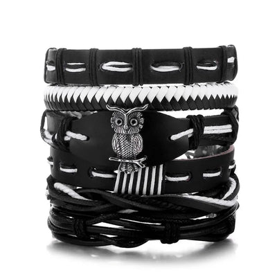 Stack of black and white leather bracelets with an owl charm on a white background