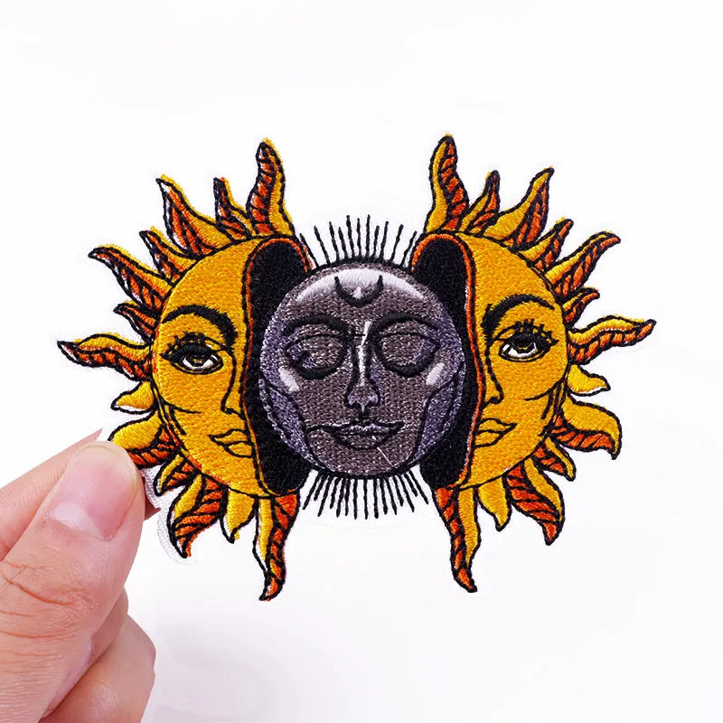 Patch with sun and moon design held by a hand on a white background