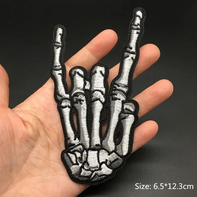 Skeleton hand patch held in a hand with a dark background