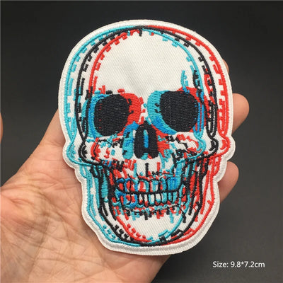 Colorful skull patch held in a hand with a dark background