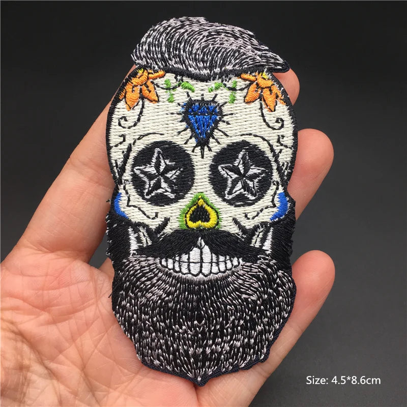 Embroidered skull patch held in a hand with a dark background
