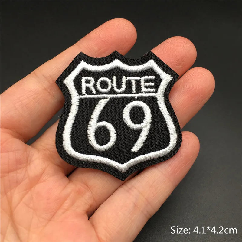 Route 69 patch held in a hand with a dark background
