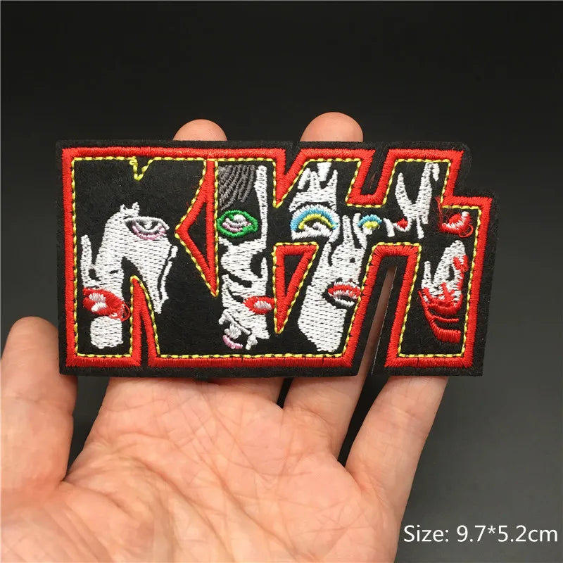 Embroidered patch with colorful design held in a hand against a dark background