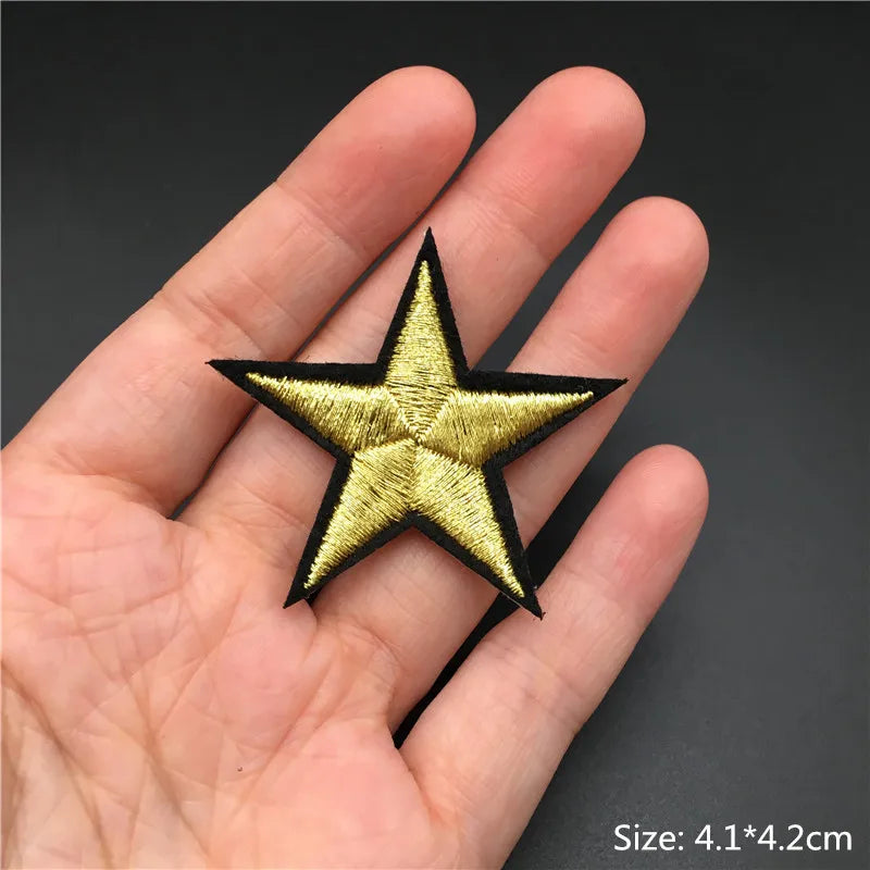 Gold star patch held in a hand with a dark background