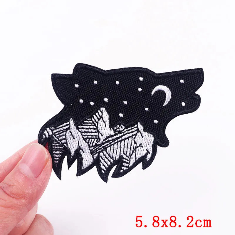 Black and white embroidered patch held by a hand with dimensions displayed.