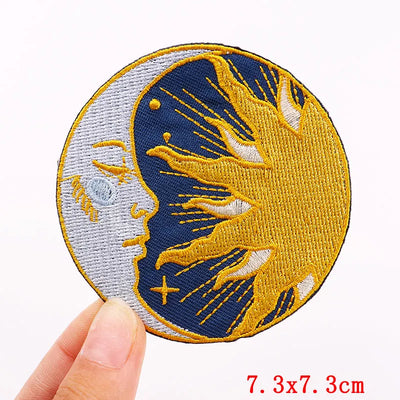 Circular patch with embroidered design held by a hand, on a white background