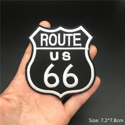 Route 66 patch held in a hand with a dark background