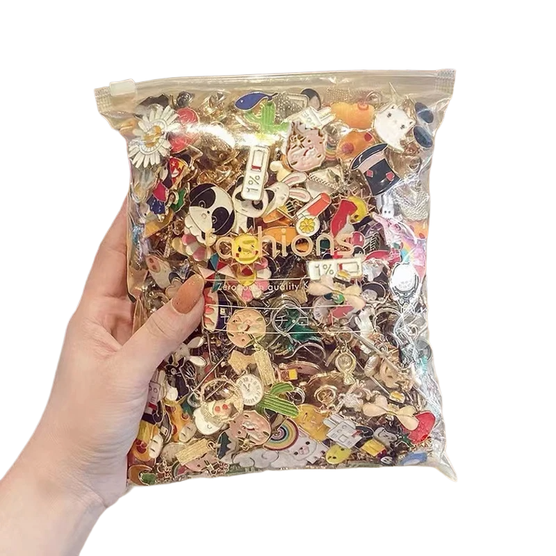 Hand holding a clear bag filled with various colorful pins against a white background