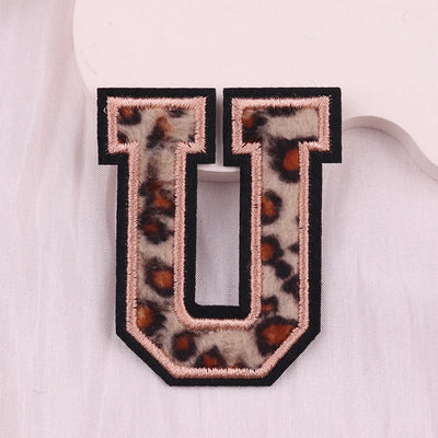 Leopard print letter 'U' patch on a light pink background