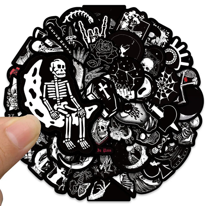 Circular sticker with black and white designs including skeletons and skulls held by a hand.