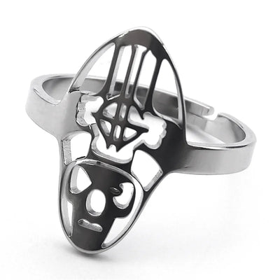 Silver ring with a unique abstract face design, featuring cut-out eyes and nose. The metal is polished, giving a sleek and modern aesthetic.