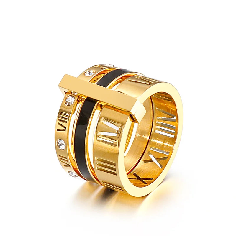 Gold ring with black center and embedded stones on a white background