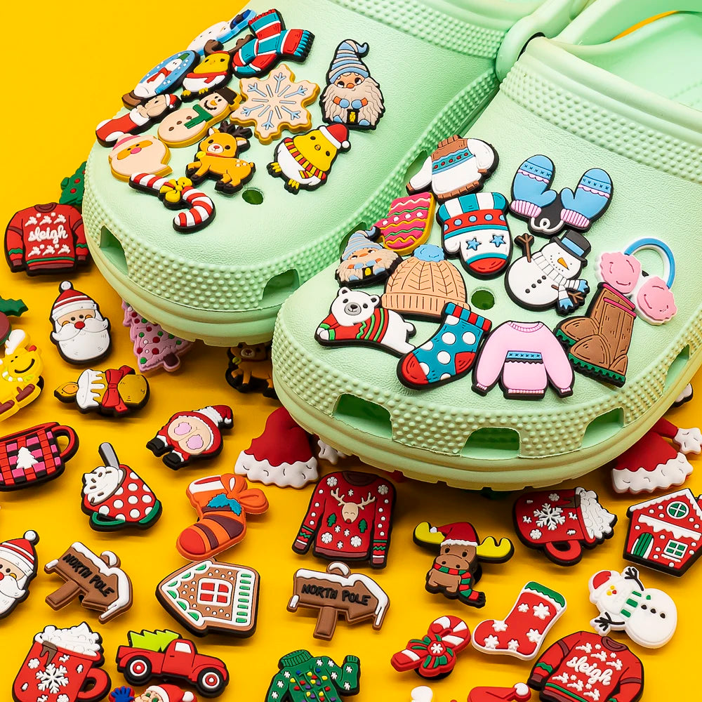 Light green Crocs shoes with colorful Christmas-themed charms on a yellow background