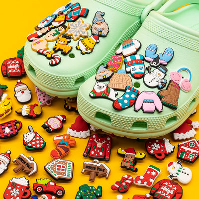 Light green Crocs shoes with colorful Christmas-themed charms on a yellow background