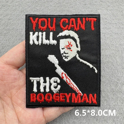Embroidered patch with text 'You can't kill the boogeyman' held by a hand on a gray background.