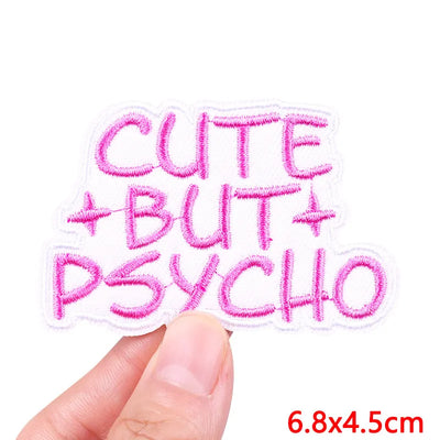 Embroidered patch with 'Cute But Psycho' text held by a hand on a white background