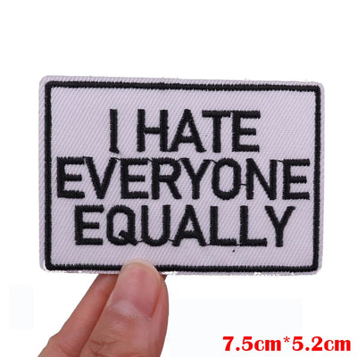 Embroidered patch with 'I HATE EVERYONE EquALLY' text held by a hand, with size measurement displayed.
