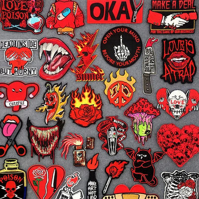 Collection of various red and black embroidered Patches  on a gray background