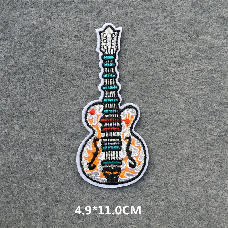 Embroidered guitar patch on a gray fabric background
