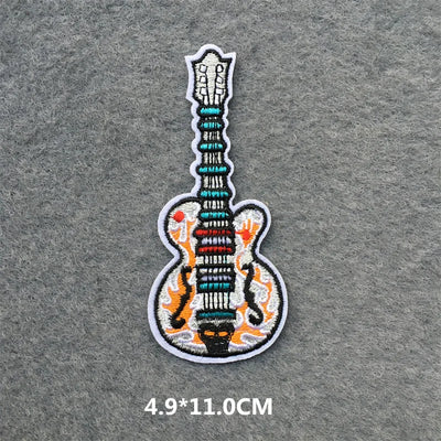 Embroidered guitar patch on a gray fabric background