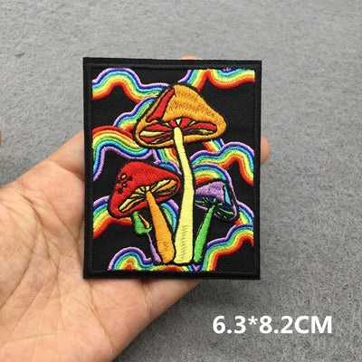 Colorful mushroom patch with rainbow design held in hand on a gray background