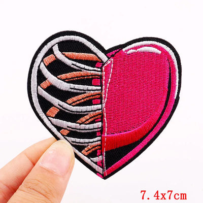 Heart-shaped patch with zebra pattern and pink center held by a hand on a white background