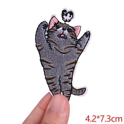Cat-shaped patch held by a hand with dimensions displayed