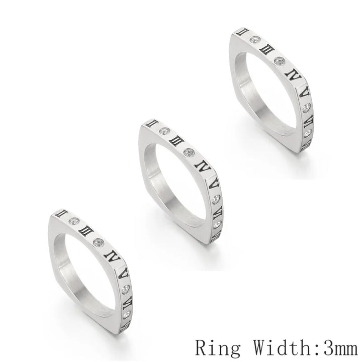 Three silver rings with Roman numeral accents on a white background